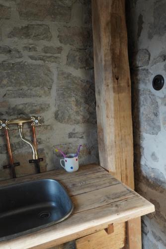 a sink in a room with a stone wall at Stodola Počúvadlo in Počúvadlo