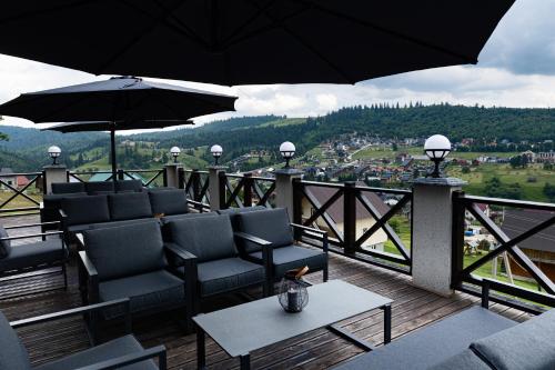 a balcony with chairs and tables and umbrellas at SVOI Hotel in Palyanytsya