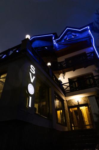 a building with a sign on the side of it at night at SVOI Hotel in Palyanytsya