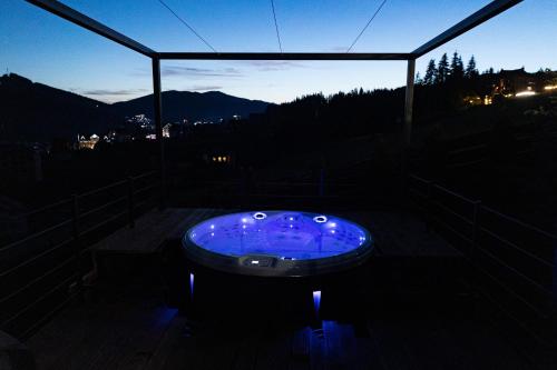 a blue tub sitting on top of a balcony at night at SVOI Hotel in Palyanytsya