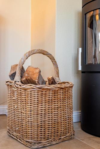 a wicker basket sitting on the floor next to a stove at Gelys Huus in Midlum