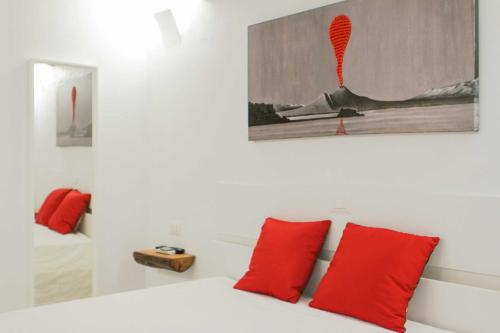 een slaapkamer met een bed met rode kussens en een schilderij bij Corno Napoletano in Napels