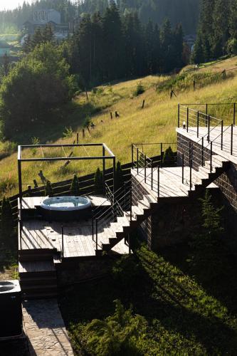 a bridge with a hot tub in a field at SVOI Hotel in Palyanytsya