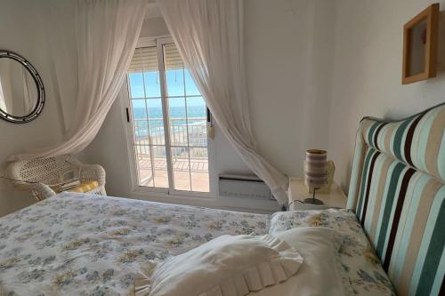 a bedroom with a bed with a view of the ocean at Apartamento con acceso directo a la playa in Valencia