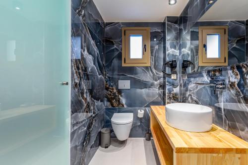 a bathroom with a sink and a toilet at Anasa Corfu in Benitses