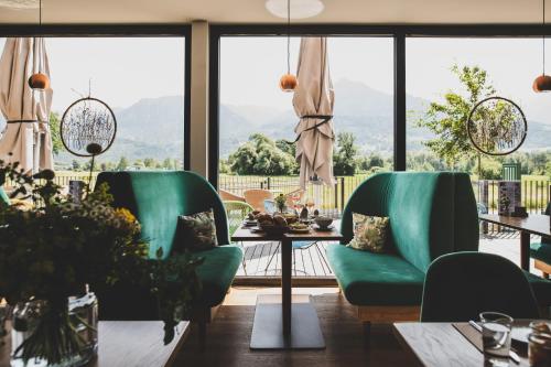 una sala da pranzo con sedie verdi e tavolo di TILL Naturhotel - Self-Check-In a Satteins