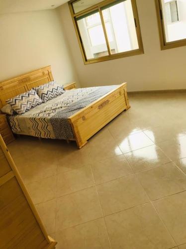 um quarto com uma cama num quarto com janelas em Un coin de tranquillité en plein cœur de l'action em Al Hoceïma