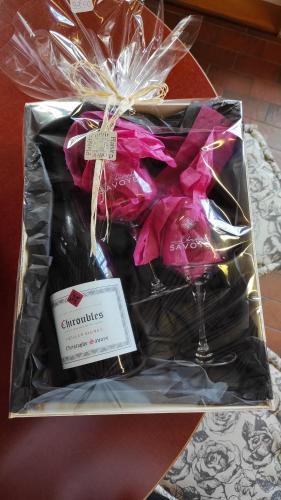 a gift box with wine glasses and pink ribbon at La Roulotte de Chiroubles in Chiroubles