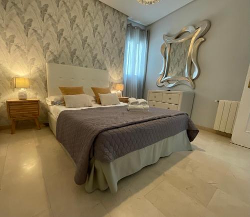 バレンシアにあるTravel Habitat Ático Calle Comediasのベッドルーム1室(ベッド1台、壁掛け鏡付)
