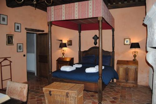 a bedroom with a canopy bed with blue sheets at Chateau de Montchoisy 