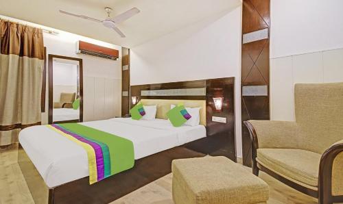 1 dormitorio con 1 cama grande y 1 silla en Aaron Residency en Nueva Delhi