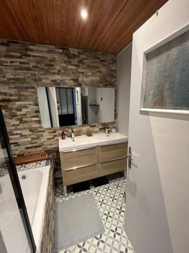 une salle de bain avec une baignoire, un lavabo et un miroir dans l'établissement Calme, vue st Victoire, proche centre ville avec parking, à Aix-en-Provence