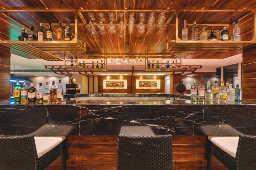 a bar with a black marble counter and chairs at Welcomhotel by ITC Hotels, Shimla in Shimla