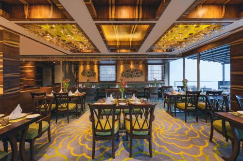 una sala da pranzo con tavoli, sedie e finestre di Welcomhotel by ITC Hotels, Shimla a Shimla