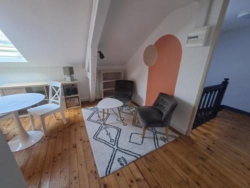 ein Wohnzimmer mit 2 Tischen und 2 Stühlen in der Unterkunft Chambre d'hôte des Thermes in Vichy