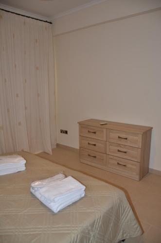 a bedroom with a dresser and a bed with white sheets at 2 Bedroom Apartment, Zygos Centre Block D - By IMH Travel & Tours in Paphos City
