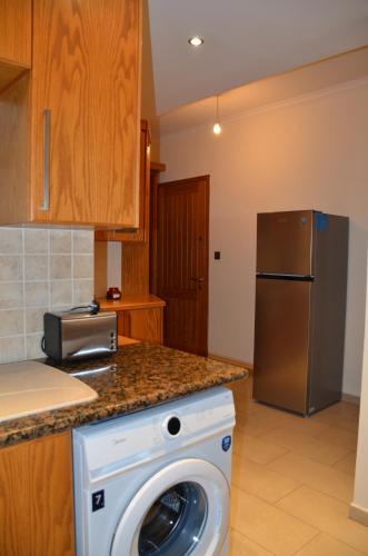a kitchen with a washing machine and a refrigerator at 2 Bedroom Apartment, Zygos Centre Block D - By IMH Travel & Tours in Paphos City