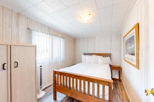 a small bedroom with a bed and a window at The Dockhouse Cottage Five in Wasaga Beach