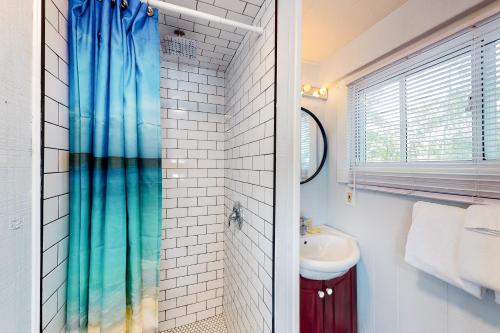 a bathroom with a shower curtain and a sink at The Lighthouse Cottage Four in Wasaga Beach