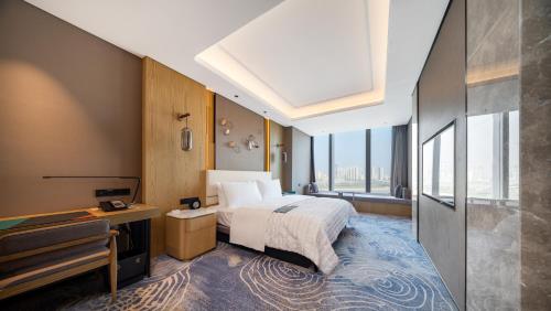 a hotel room with a bed and a television at Le Meridien Xi'an Chanba in Xi'an