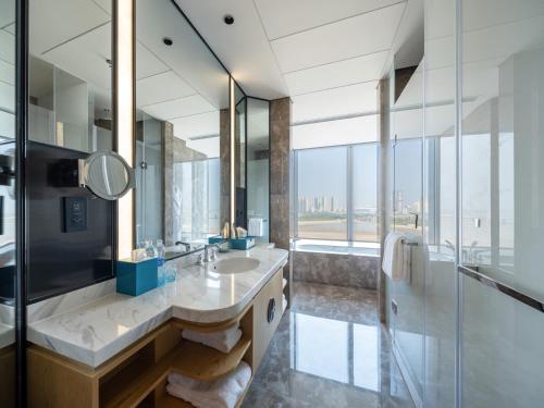 baño con 2 lavabos y espejo grande en Le Méridien Xi'an Chanba en Xi'an