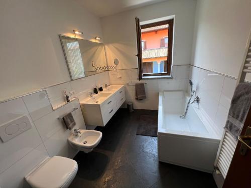 łazienka z toaletą, umywalką i wanną w obiekcie Ortensia w mieście Baveno