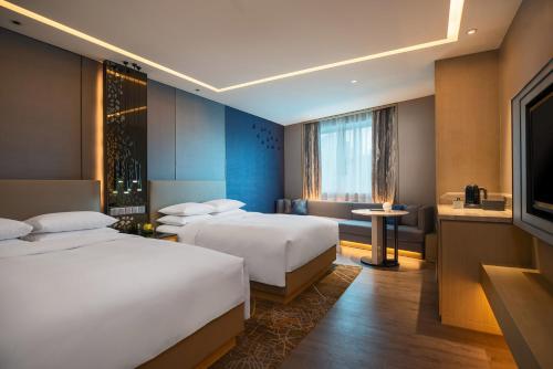 um quarto de hotel com duas camas e uma televisão em Renaissance Shenzhen Luohu Hotel em Shenzhen