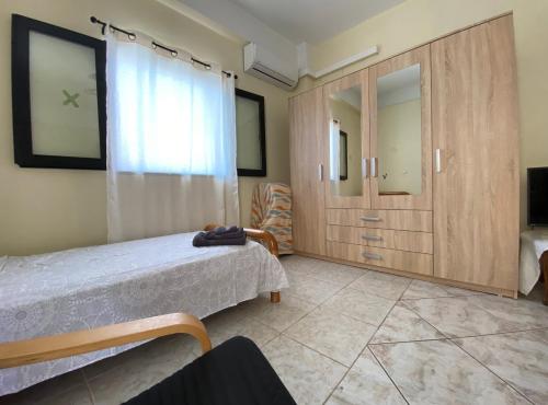 a bedroom with a bed and a large window at Sunny Apartment Amaliada in Amaliás