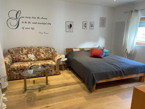ein Schlafzimmer mit einem Bett und einem Sofa in der Unterkunft DreiländerOase in Perl