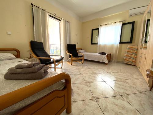 a bedroom with two beds and a living room at Sunny Apartment Amaliada in Amaliás