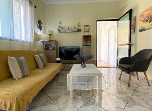 a living room with a couch and a table at Sunny Apartment Amaliada in Amaliás