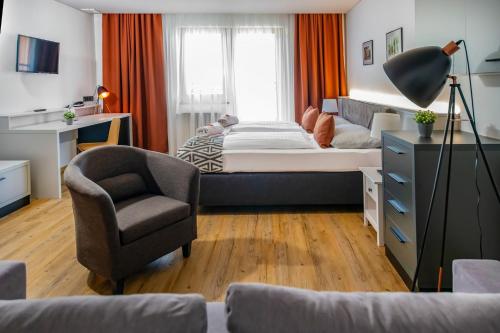 a small bedroom with a bed and a chair at Hotel Alpenblick Kreischberg in Sankt Lorenzen ob Murau