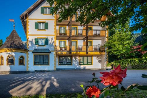 a large yellow building with a balcony at Hotel Alpenblick Kreischberg in Sankt Lorenzen ob Murau