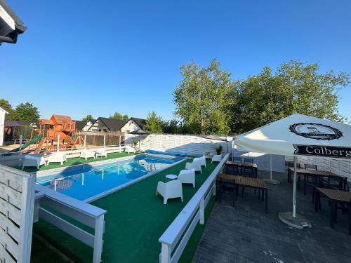 隱海市的住宿－Domki letniskowe Layla，一个带桌椅和遮阳伞的游泳池
