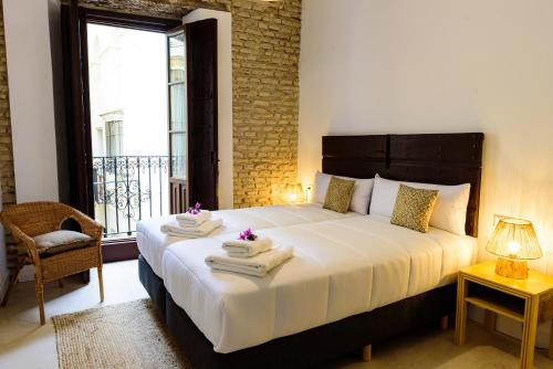 1 dormitorio con 1 cama grande y toallas. en Casa de los Venerables en Sevilla