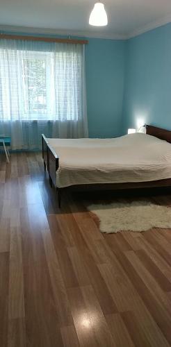 a bedroom with a large bed and a wooden floor at уют in Rustavi