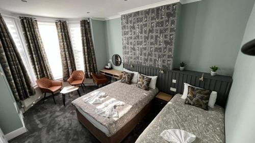 a bedroom with two beds and a table and chairs at Charlotte Guest House in London