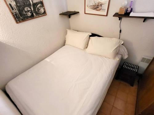 - un lit blanc avec deux oreillers dans l'établissement T2 avec parking, piscine, tennis - 200m plages et commerces - FR-1-316-58, à Six-Fours-les-Plages