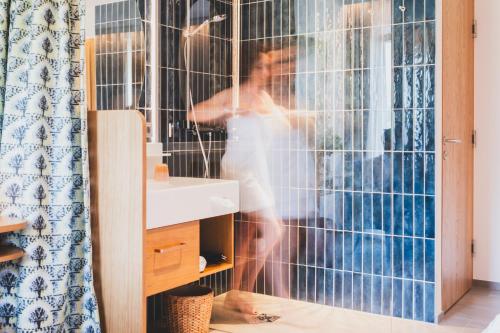 a woman is standing in front of a window in a bathroom at TILL Naturmotel - Self-Check-In in Satteins