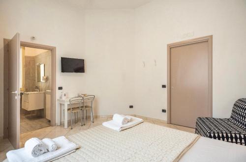 Habitación blanca con cama y silla en Tuanis en Nápoles