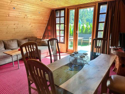uma sala de jantar com uma mesa de madeira e cadeiras em Alpine chalet NIRVANA em Borovets