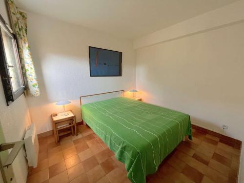 - une chambre avec un lit recouvert de vert dans l'établissement Appartement 2P 4 Couchages avec Piscine, Tennis et Parking à La Croix-Valmer - FR-1-226B-174, à La Croix-Valmer