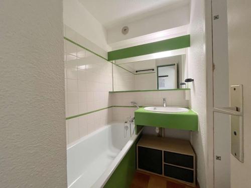 La salle de bains est pourvue d'un lavabo vert et d'une baignoire. dans l'établissement Appartement 2P 4 Couchages avec Piscine, Tennis et Parking à La Croix-Valmer - FR-1-226B-174, à La Croix-Valmer
