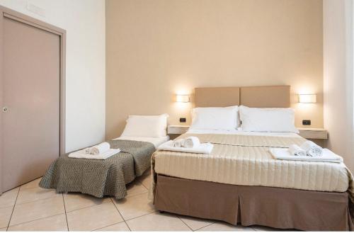 una camera con due letti e asciugamani di Tuanis a Napoli