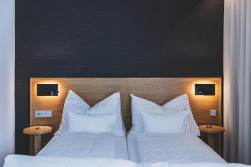 - 2 lits dans une chambre d'hôtel avec des oreillers blancs dans l'établissement TILL Naturhotel - Self-Check-In, à Satteins