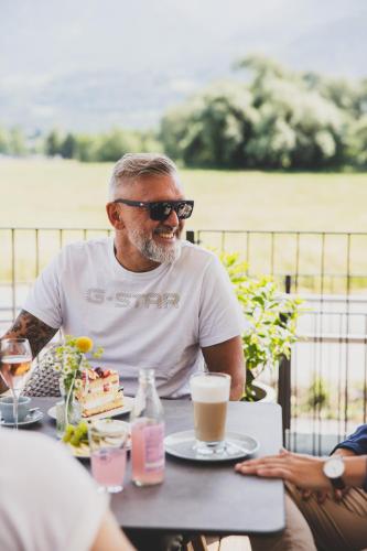 a man sitting at a table with a piece of cake at TILL Naturhotel - Self-Check-In in Satteins