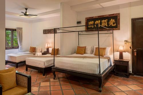a hotel room with two beds and a couch at Pavillon Indochine Boutique - Hotel in Siem Reap