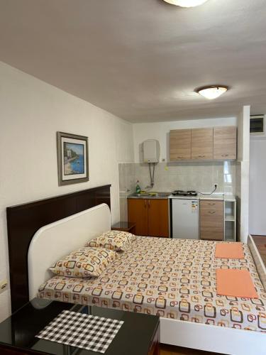 a small bedroom with a bed and a kitchen at Apartments Jankovic in Podgorica