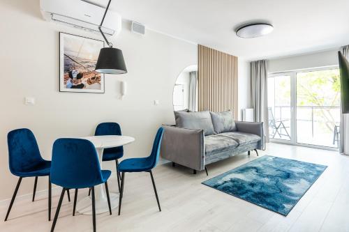 a living room with a couch and a table and chairs at Art Boulevard in Mrzeżyno