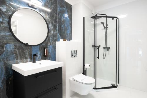 a bathroom with a sink toilet and a mirror at Art Boulevard in Mrzeżyno